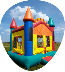 A colorful inflatable bounce house with turrets invites Bouncy House Fun on a grassy field under a blue sky with scattered clouds.