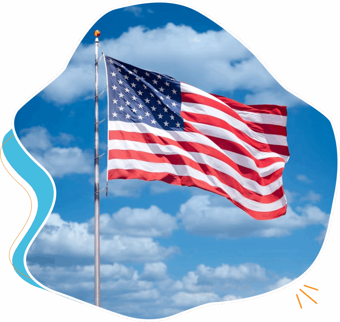 American flag waving against a blue sky with clouds.